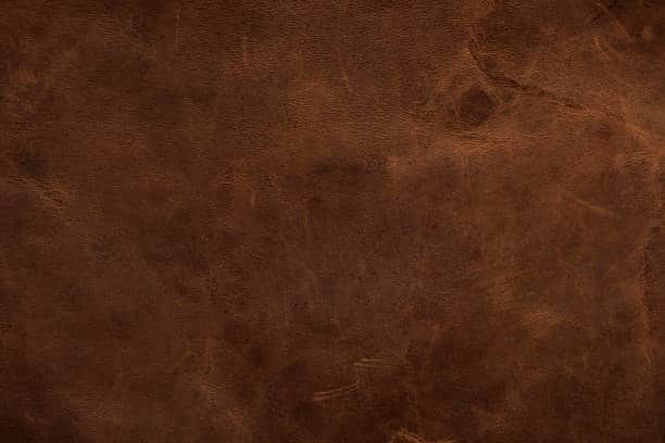 Texture of brown leather, representing a durable cloth fabric type often used in premium apparel and accessories.