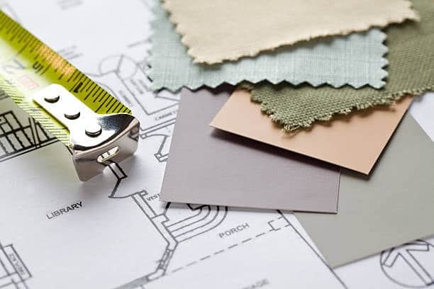 Fabric swatches and color cards placed on design blueprints.