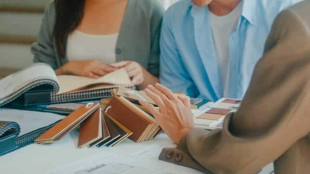 People reviewing fabric swatches for material selection during consultation.