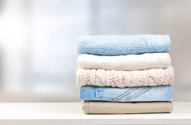 Stack of folded clothes made from different fabric types for clothing.