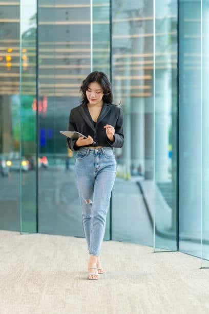 Woman walking in high-waisted jeans, showcasing a style that requires specific yards of fabric for sewing.