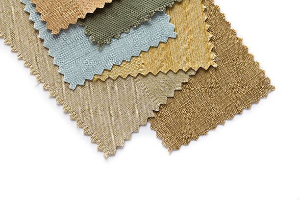 Stack of luxury fabric swatches with textured patterns.