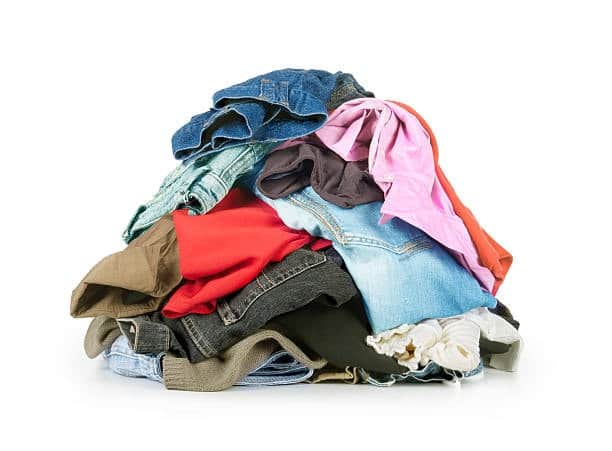 Pile of different types of clothing fabrics including denim, cotton, and synthetics.