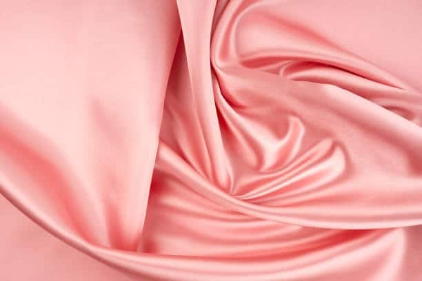 Pink satin fabric with a shiny, soft, and luxurious surface.