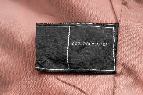 Close-up of a garment label showing 100% polyester, illustrating a synthetic cloth fabric type used in apparel.