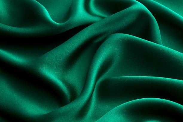 Smooth green satin fabric showing a soft and luxurious texture.
