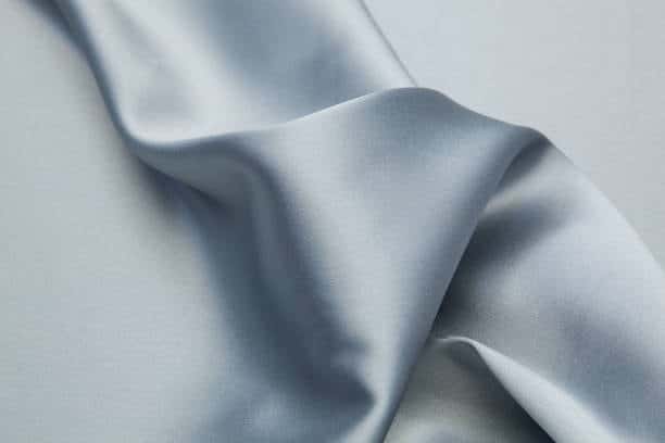 Smooth light blue satin fabric with glossy and flowing texture.
