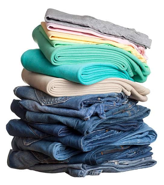 Stack of mixed fabrics including denim and fleece, representing various cloth fabric types used in apparel design.