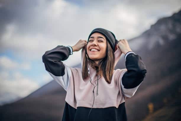 Cheerful woman outdoors wearing a color-block hoodie, illustrating active lifestyle and hoodie functionality