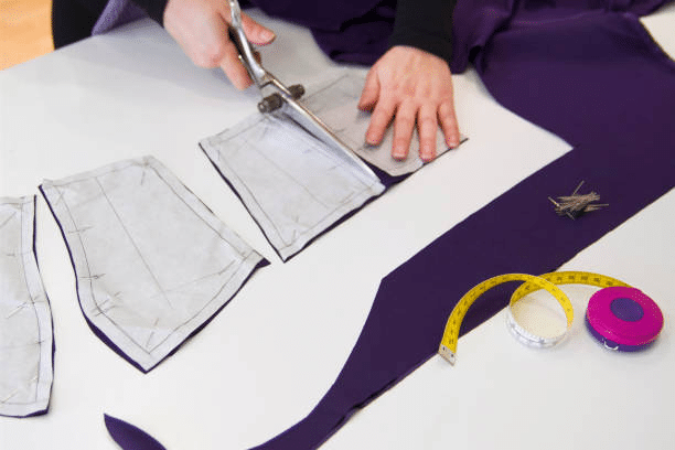 Manual fabric cutting using patterns during clothing production process