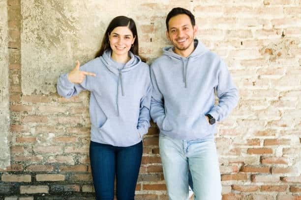 Happy couple in light gray hoodies standing together, reflecting comfort and couple fashion