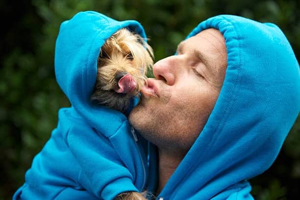 Man and his dog wearing matching blue hoodies, highlighting the hoodie’s fun and cozy appeal.