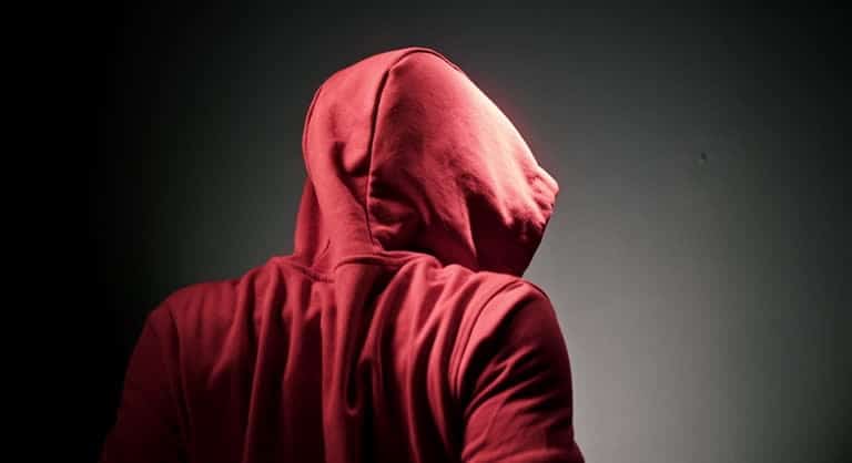Back view of a red hoodie under dramatic lighting, highlighting the hooded design and silhouette