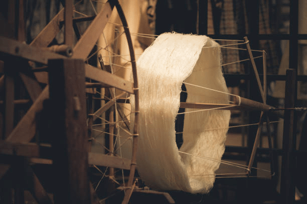 Traditional spinning wheel converting fiber into yarn for garment making